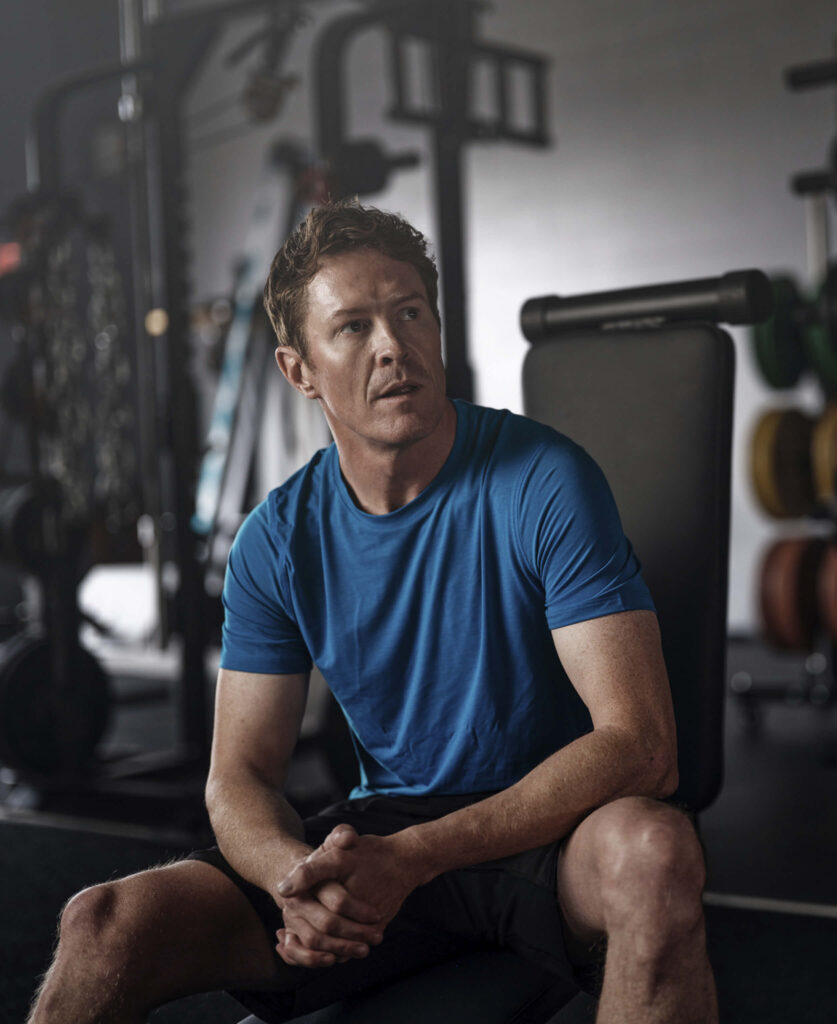 Scott Dixon sits on a bench at the gym between work sets.