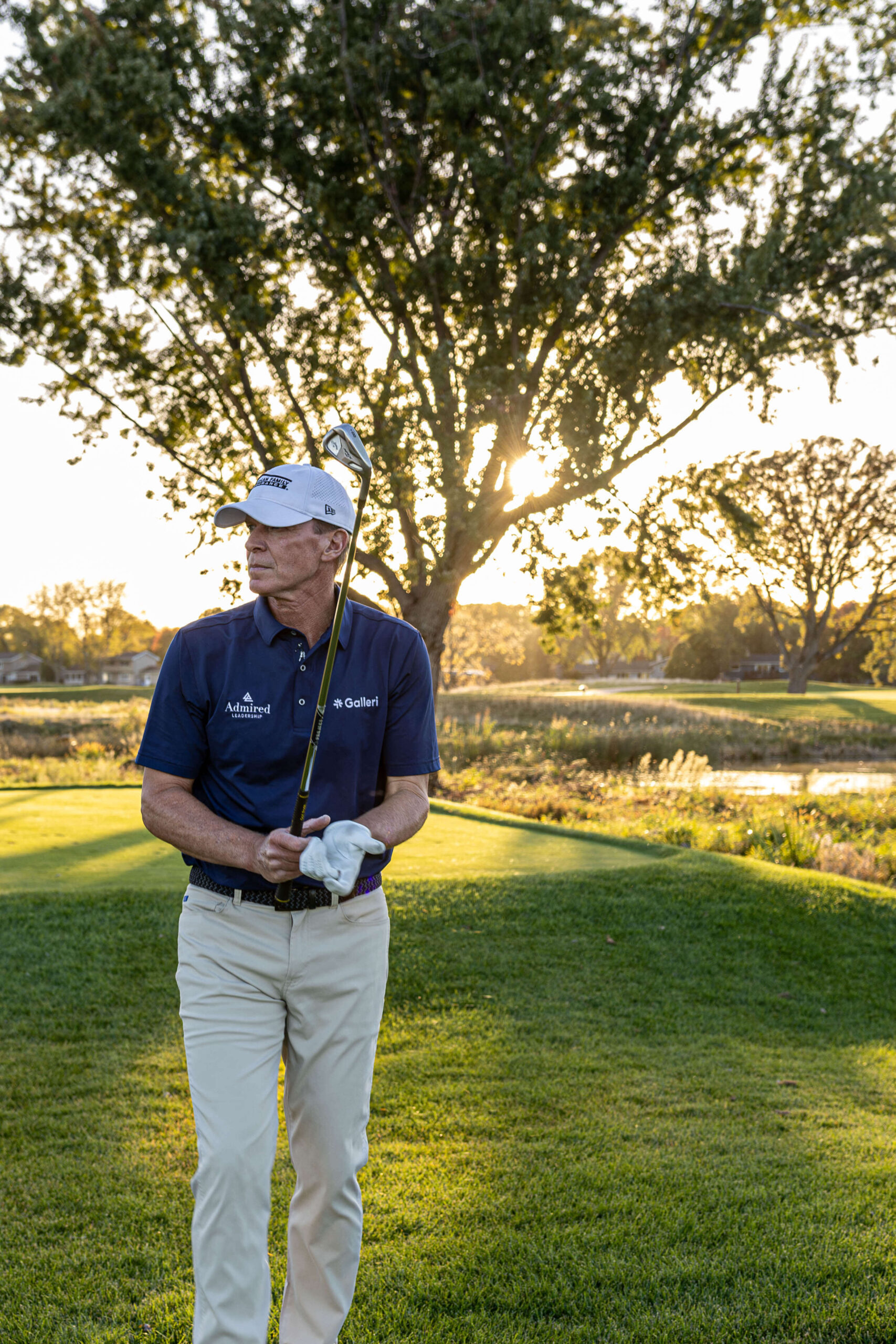 Steve Stricker takes off his gloves after hitting a golf ball.